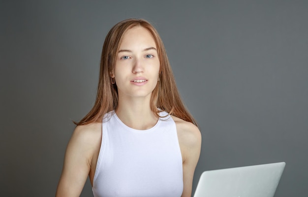 Mujer mirando en la computadora portátil en casa leyendo noticias en línea en internet