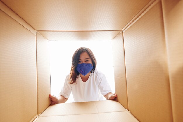 Mujer mirando dentro de una caja de cartón