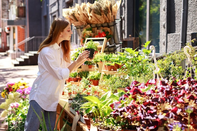 Mujer mirando flores en una tienda.