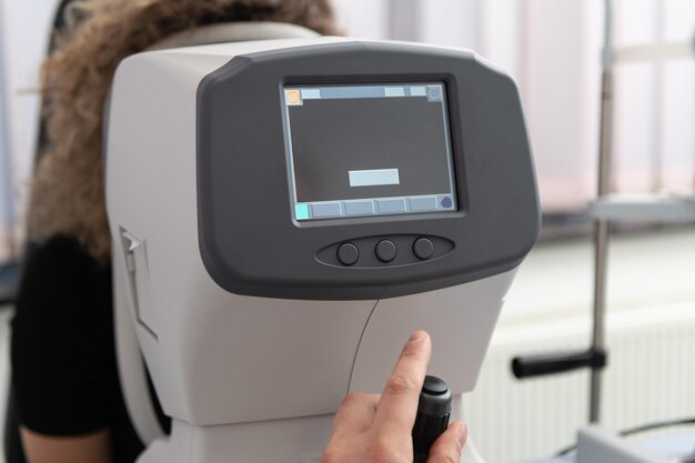 Mujer mirando la máquina de prueba ocular refractómetro