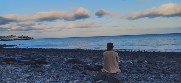 Mujer mirando el mar al atardecer en Lanzarote