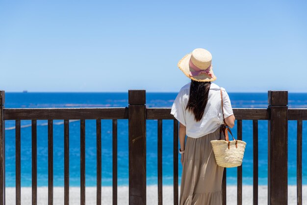 Mujer mirando el mar en verano