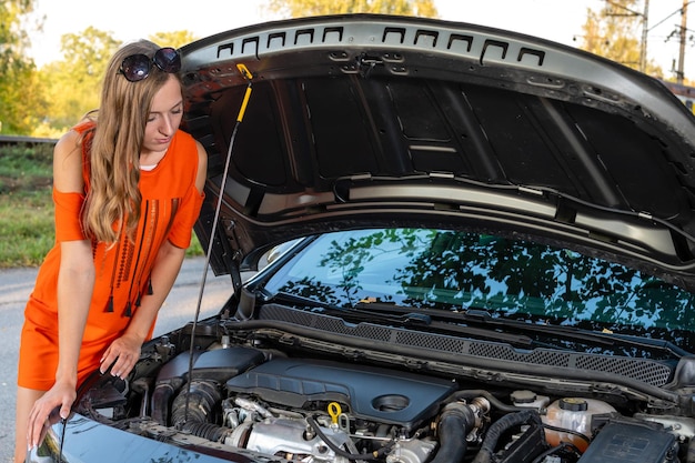 Mujer mirando el motor del coche