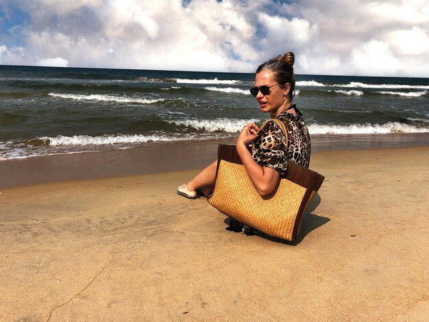 Mujer mirando hacia otro lado mientras está sentada en la playa