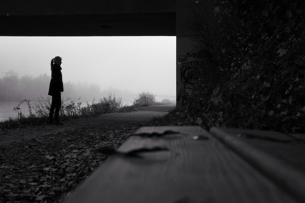 Foto mujer mirando hacia otro lado mientras está de pie en la acera