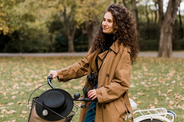Foto mujer mirando a otro lado y sosteniendo la bicicleta