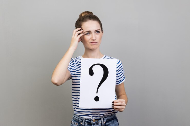 Foto mujer mirando hacia otro lado sosteniendo papel con signo de interrogación piensa en resolver el problema