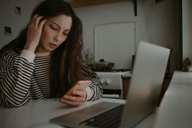 Mujer mirando en la pantalla del móvil con cara infeliz leyendo noticias