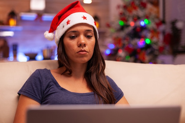 Foto mujer mirando la pantalla del portátil leyendo el correo electrónico comercial durante las vacaciones de navidad