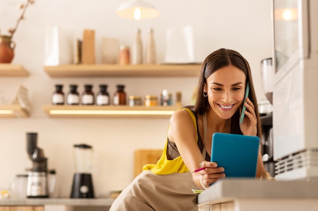 Mujer mirando la pantalla en la tableta mientras ordena alimentos en línea