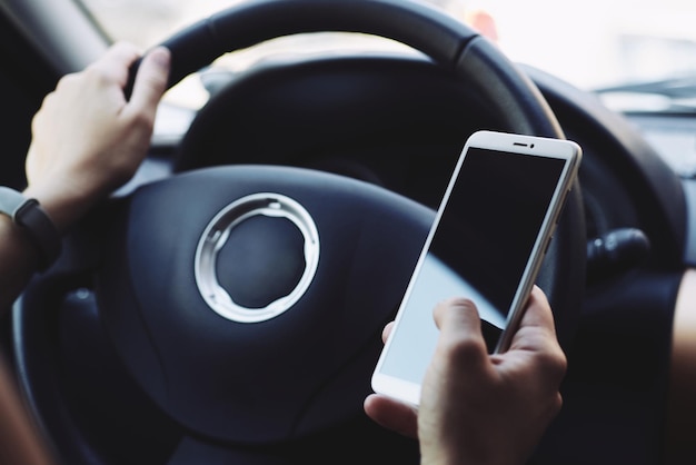 Mujer mirando la pantalla del teléfono inteligente en el auto