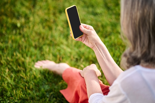 Mujer mirando la pantalla del teléfono inteligente con interés