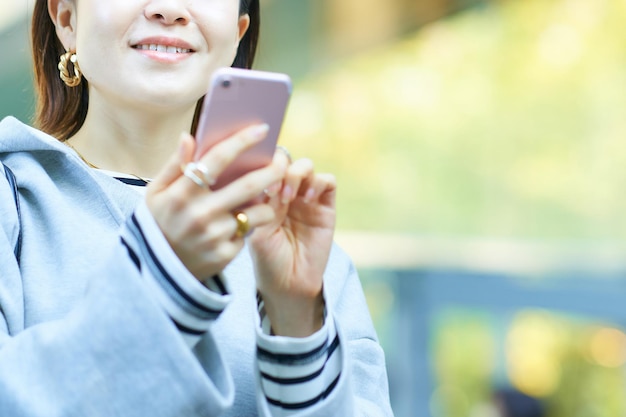 Mujer mirando la pantalla del teléfono inteligente