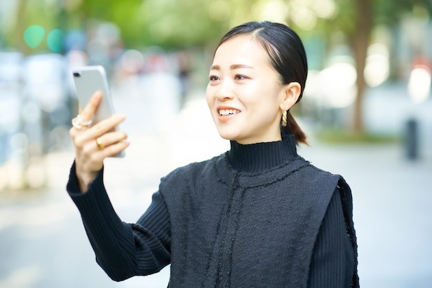 Mujer mirando la pantalla del teléfono inteligente