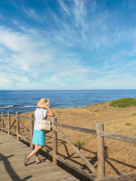 Mujer mirando la playa de Cabo Pino España