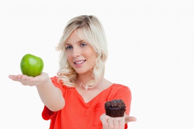 Mujer mirando su comida favorita entre manzana y panecillo