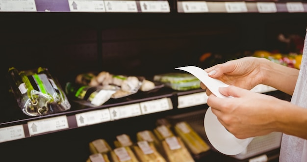 Una mujer mirando su lista de compras