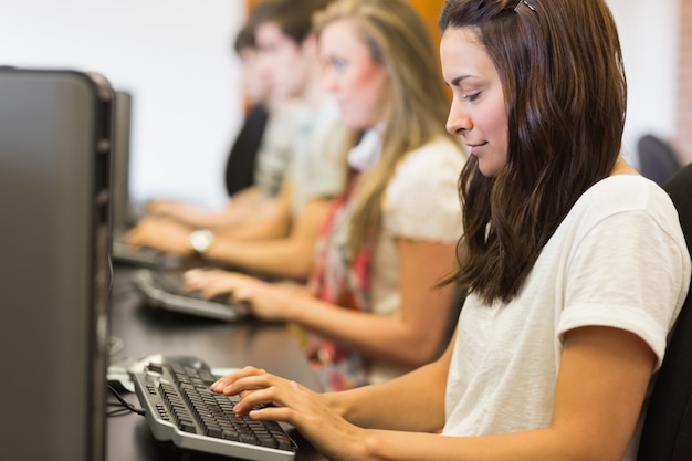 Mujer mirando el teclado en clase de informática en la universidad