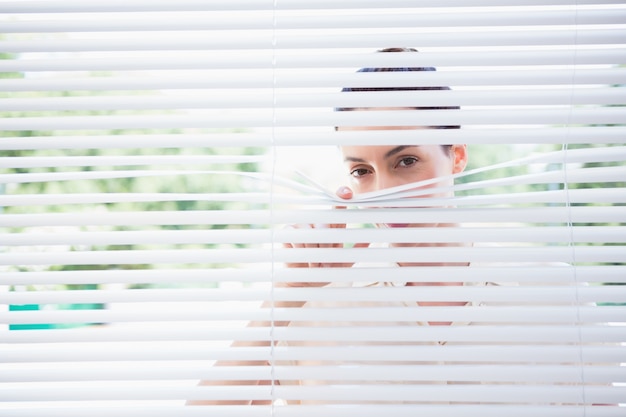 Mujer mirando a través de las persianas