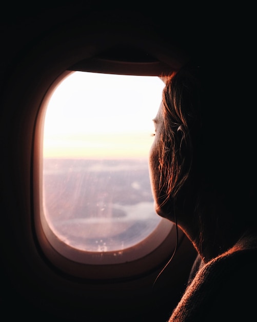 Mujer mirando a través de la ventana del avión