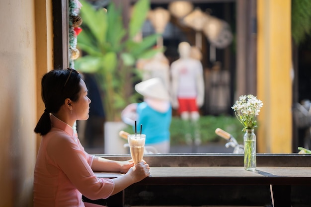 Foto mujer mirando por la ventana en el café