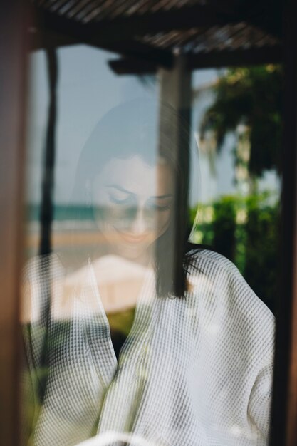 Mujer mirando por la ventana de su habitación de hotel