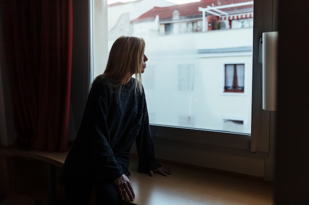 Mujer mirando por la ventana