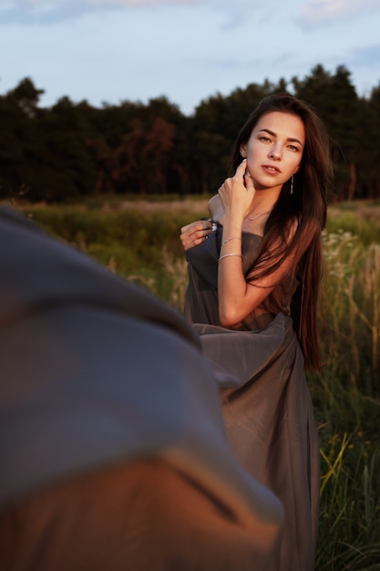 Mujer mística con un vestido gris en la naturaleza