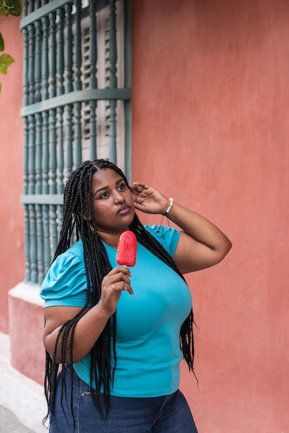 Mujer mixta comiendo paletas en la calle