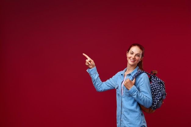 Mujer con una mochila apuntando hacia el lado