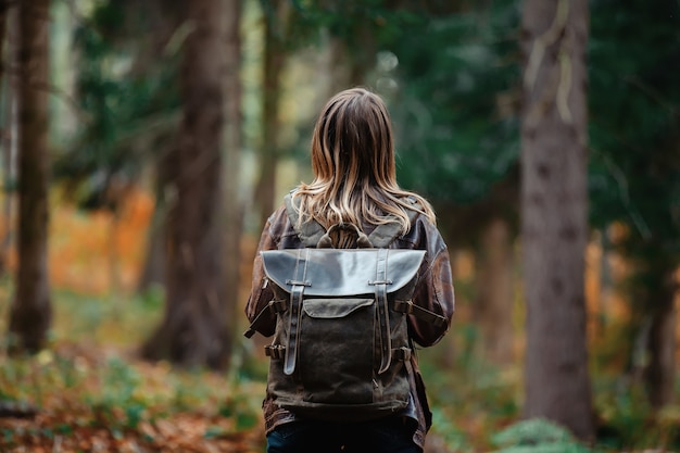 mujer con una mochila en el bosque de otoño
