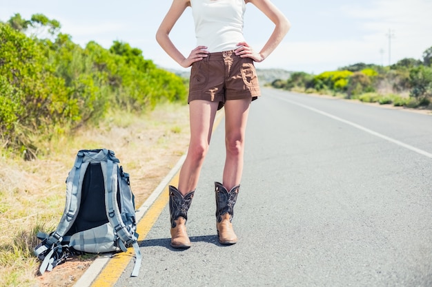 Mujer con mochila en la carretera posando