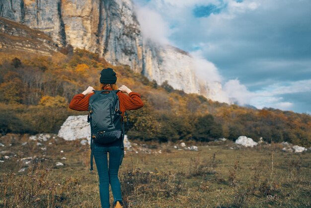 Foto mujer con mochila están descansando en las montañas en la naturaleza y el otoño hojas amarillas paisaje foto de alta calidad