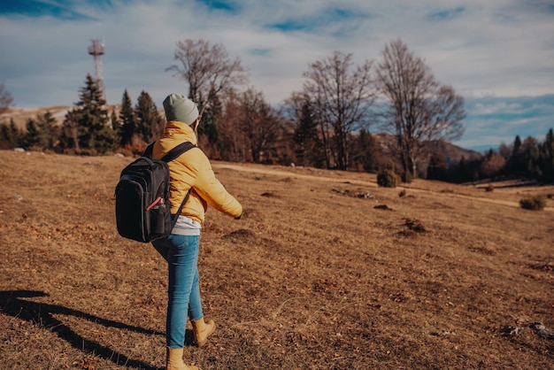 Mujer con una mochila de excursionistas en un día soleado