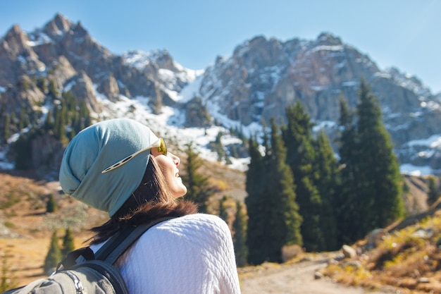 Una mujer con mochila hace una escalada en la montaña. Cielo azul.