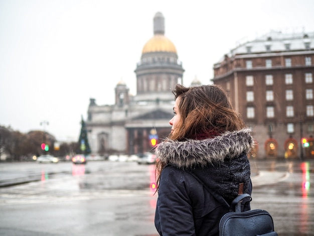 Mujer con mochila mirando la Catedral de San Isaac y la plaza principal de San Petersburgo