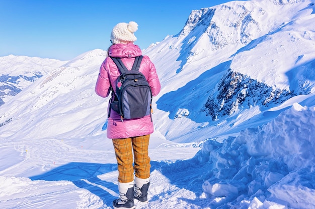 Mujer con mochila mirando las laderas nevadas del glaciar Hintertux en Tirol en Mayrhofen en el valle de Zillertal, Austria, Alpes de invierno. Lady girl en la estación de esquí de Hintertuxer Gletscher en las montañas alpinas