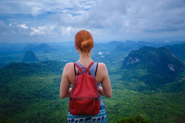 Mujer con una mochila mirando las montañas