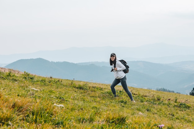 Mujer con mochila de senderismo en la temporada de otoño de las montañas