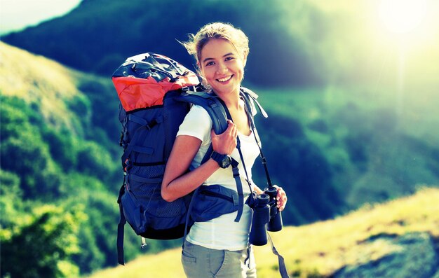 Mujer con mochila trekking por las montañas