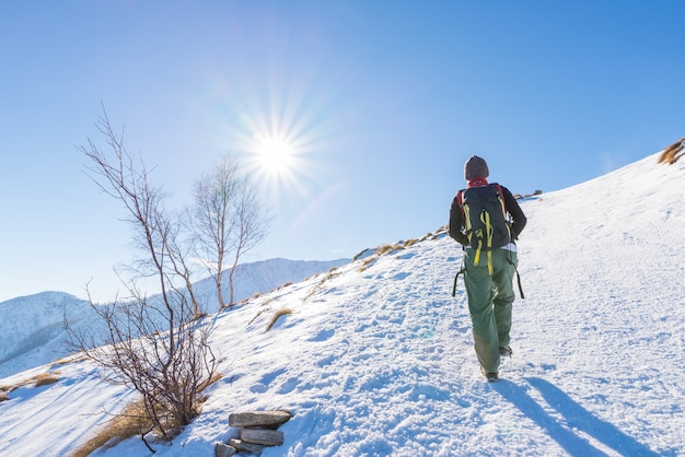 Mujer mochilero trekking en la nieve en los Alpes.