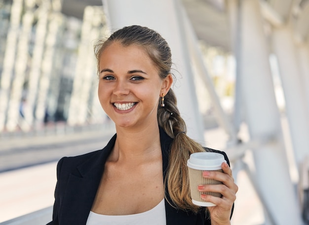 Una mujer de moda alegre con café al aire libre