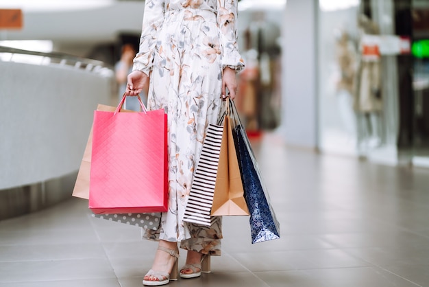 Mujer de moda con bolsos multicolores en el centro comercial. La alegría del consumo.