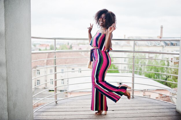 Mujer de moda y feliz en mono rosa a rayas