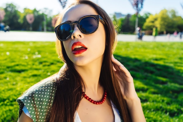 Mujer de moda glamour en gafas de sol, horario de verano, labios rojos