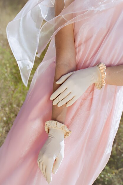 mujer de moda con guantes beiges y vestido rosa