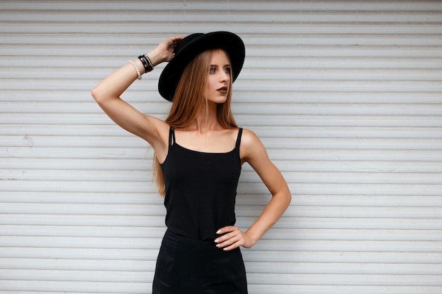 Mujer de moda hermosa joven con un sombrero negro