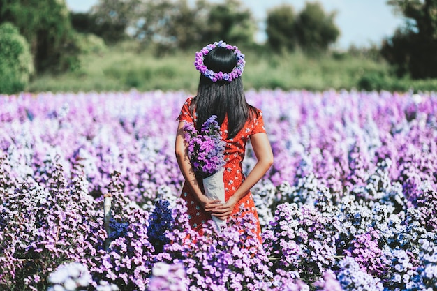 Mujer de moda en jardín de flores, vista posterior