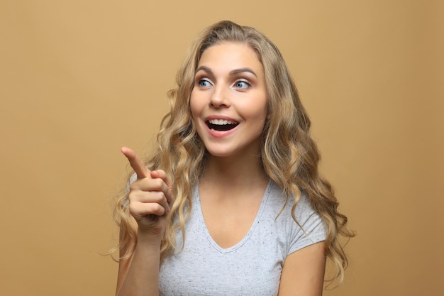 Mujer de moda joven feliz posando para la cámara mientras le apunta.