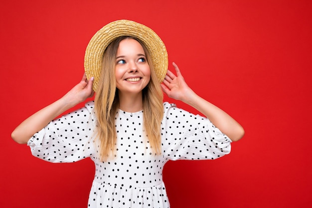 Mujer de moda joven hermosa en vestido casual de verano y sombrero de paja muestra femenina positiva facial